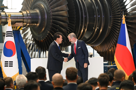 Korean President Yoon Suk Yeol, left, and Czech Prime Minister Petr Fiala shake hands after signing agreements on nuclear energy cooperation at Doosan Skoda Power in the Plzen industrial park in the Czech Republic on Friday. [PRESIDENTIAL OFFICE] 