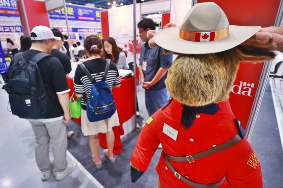 Attendees check out Canada's booth at the International Education & Emigration Fair at Coex in southern Seoul on Sunday. [YONHAP]