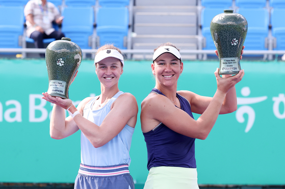 Liudmila Samsonova of Russia, left, and Nicole Melichar-Martinez of the United States pose with trophies after winning the 2024 Hana Bank Korea Open doubles final at Seoul Olympic Park Tennis Center in southern Seoul on Sunday. [NEWS1]