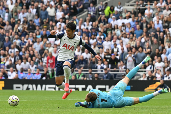 Tottenham Hotspur captain Son Heung-min, left, tries to take the ball around Brentford goalkeeper Mark Flekken during a Premier League match at Tottenham Hotspur Stadium in London on Saturday. [AFP/YONHAP]