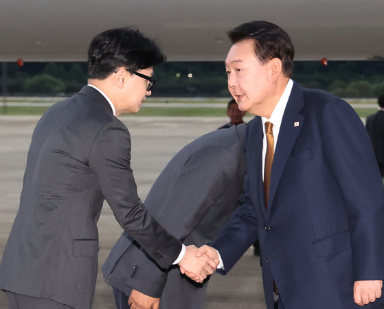 President Yoon Suk Yeol, right, is greeted by People Power Party Chairman Han Dong-hoon, left, as he arrives at Seoul Air Base in Seongnam, Gyeonggi, Sunday morning, ending a four-day official visit to the Czech Republic. [JOINT PRESS CORPS] 