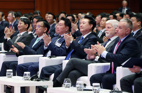 President Yoon Suk Yeol, third from right, Czech President Petr Pavel, second from right, and SK Group Chairman Chey Tae-won, head of the Korea Chamber of Commerce and Industry, third from left, clap alongside other officials and business executives at the Korea-Czech business forum at a hotel in Prague in the Czech Republic on Friday. [JOINT PRESS CORPS]