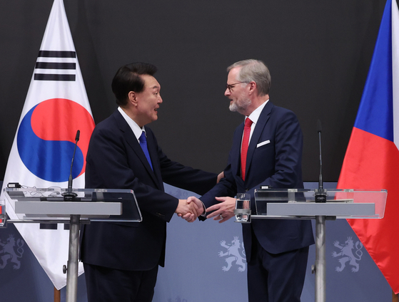 President Yoon Suk Yeol, left, shakes hands with Czech Prime Minister Petr Fiala after holding a joint news conference at Liechtenstein Palace in Prague on Friday. [JOINT PRESS CORPS]