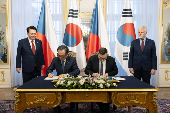 Korean President Yoon Suk Yeol, back left, and Czech President Petr Pavel, back right, watch Korean Foreign Minister Cho Tae-yul and his Czech counterpart, Jan Lipavsky, sign a memorandum of understanding on cooperation for Ukraine’s reconstruction at Prague Castle on Thursday. [PRESIDENTIAL OFFICE]