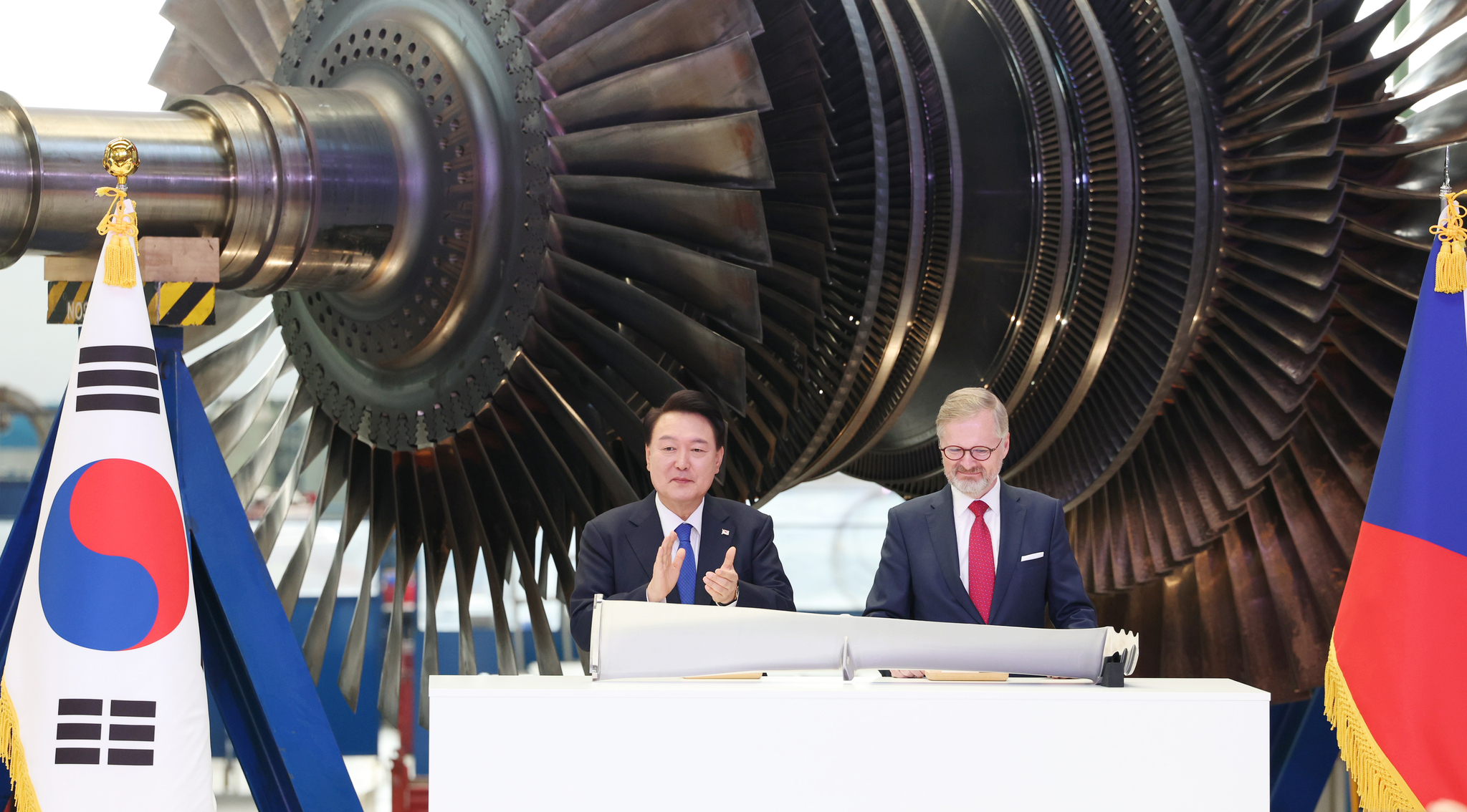 Korean President Yoon Suk Yeol, left, and Czech Prime Minister Petr Fiala clap after signing a turbine blade at Doosan Skoda Power in the Plzen industrial park in the Czech Republic on Friday. [JOINT PRESS CORPS]