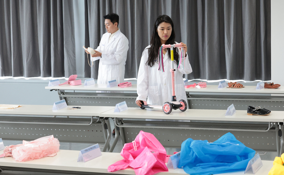 This photo taken on June 27 shows officials at the Korean Agency for Technology and Standards inspecting products subject to recalls. [YONHAP]