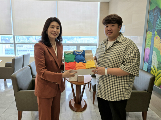 You Hye-mi, senior presidential secretary for low birthrate issues, left, delivers a presidential gift to the father of quintuplet newborns on Sunday. [PRESIDENTIAL OFFICE]