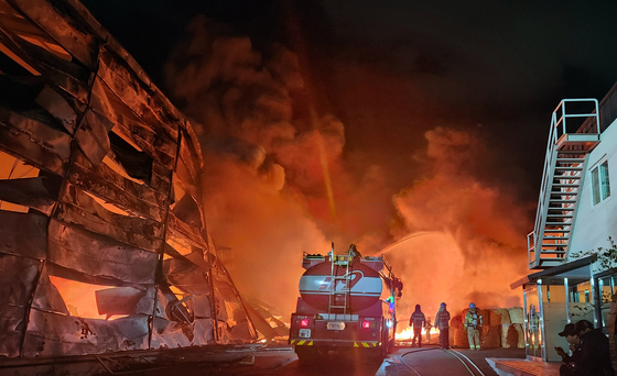 Firefighters extinguish the blaze which was spreading at a factory in Gunsan, North Jeolla, on Monday. [JEONBUK FIRE SECURITY HEADQUARTERS]