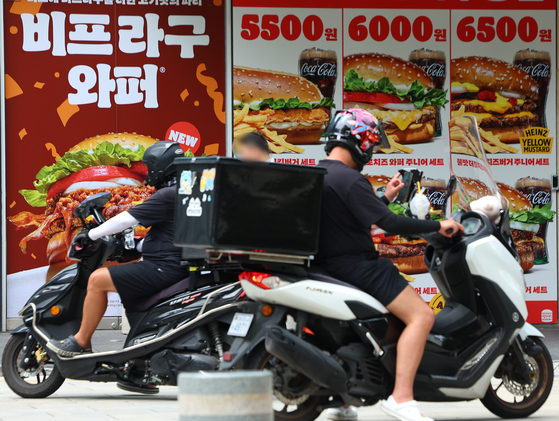 Delivery drivers outside a Burger King restaurant in central Seoul [YONHAP]