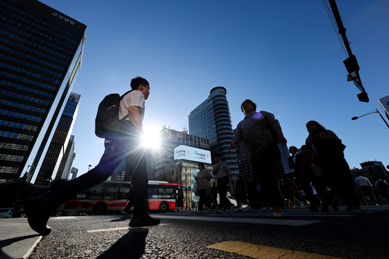 People walk near Gwanghwamun in downtown Seoul under a clear blue sky on Monday morning. [YONHAP]