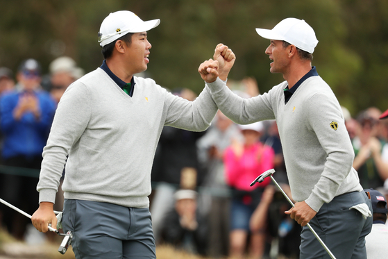 An Byeong-hun and Adam Scott of Australia and the International Team react on the 17th green during four-ball matches on day three of the 2019 Presidents Cup at Royal Melbourne Golf Course on Dec. 14, 2019 in Melbourne, Australia. [GETTY IMAGES]