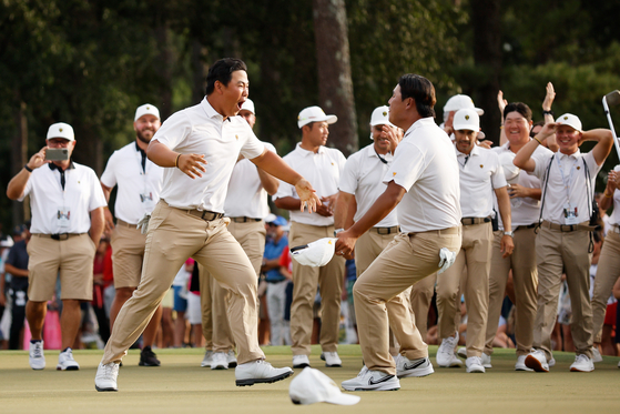 Tom Kim, left, and Kim Si-woo celebrate on day three of the 2022 Presidents Cup at Quail Hollow Country Club in Charlotte, North Carolina on Sept. 24, 2022.  [GETTY IMAGES]