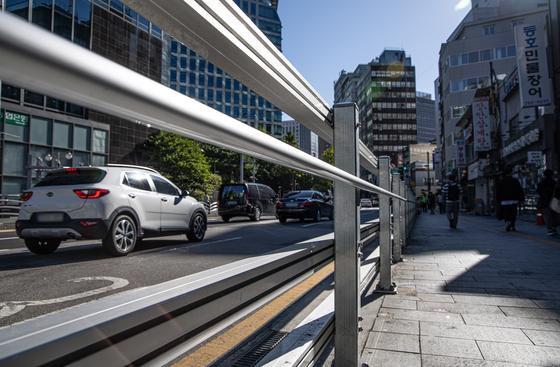 Cars pass by the steel fencing newly installed at the site of the fatal car accident near City Hall in downtown Seoul on Tuesday. The accident in July resulted in nine deaths. [NEWS1] 