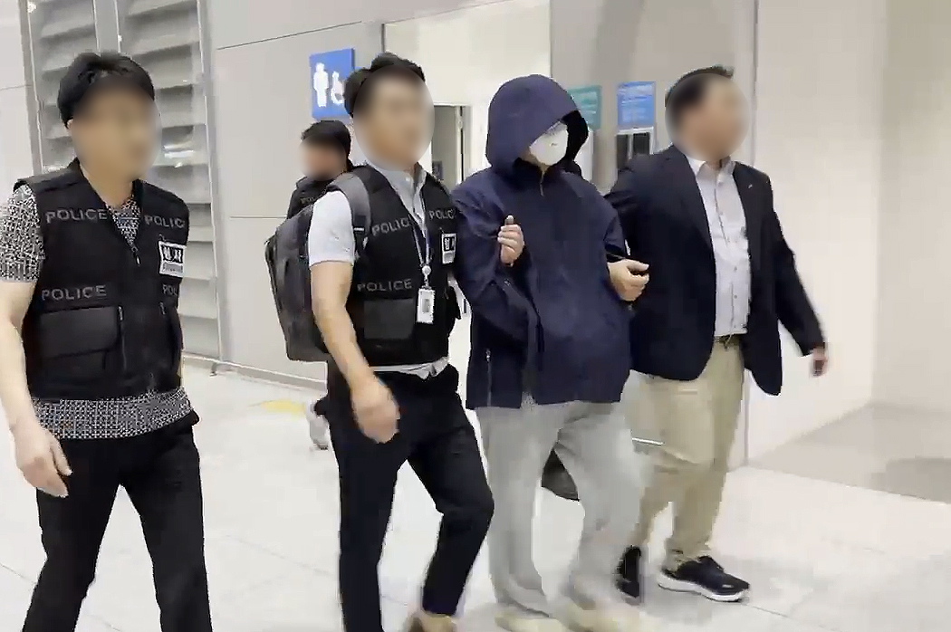 A suspect, 39, who is accused of murdering a Korean tourist in Thailand, is extradited to Korea from Vietnam on Tuesday. The image shows the suspect being escorted by law enforcers at Incheon International Airport on the same day. [NEWS1] 