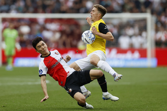 Feyenoord midfielder Hwang In-beom, left, fights for the ball with NAC Breda's Max Balard during an Eredivisie match in Rotterdam, Netherlands on Sunday. [AFP/YONHAP] 