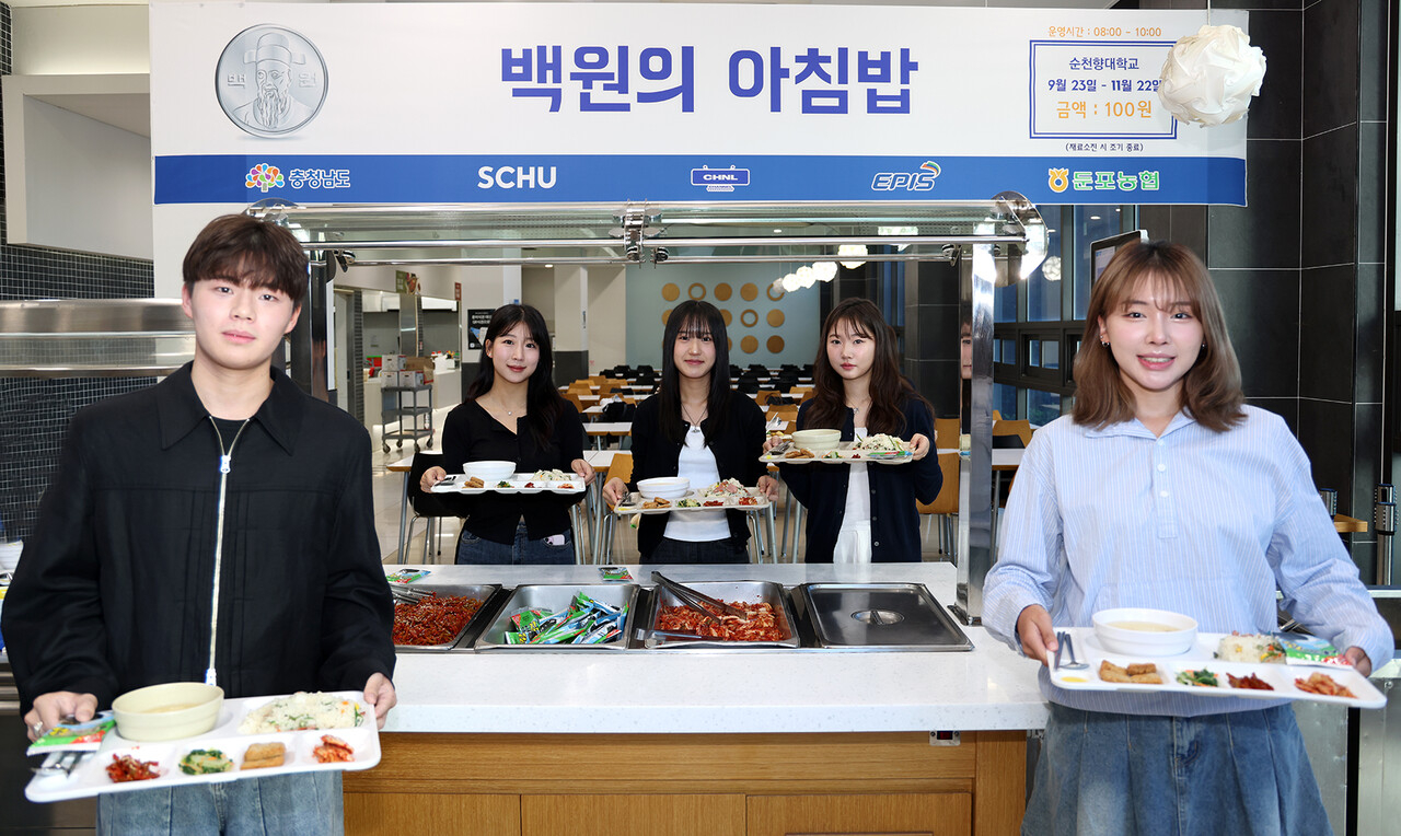 Students pose for a photo while holding the100 won ($0.07) breakfast offered at Soonchunhyang University. [SOONCHUNHYANG UNIVERSITY]