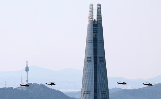 Military helicopters conduct a flight rehearsal around Lotte World Tower in southern Seoul, as seen from Namhansanseong, a fortress in Gwangju, Gyeonggi, on Tuesday, a week before Armed Forces Day. [NEWS1] 