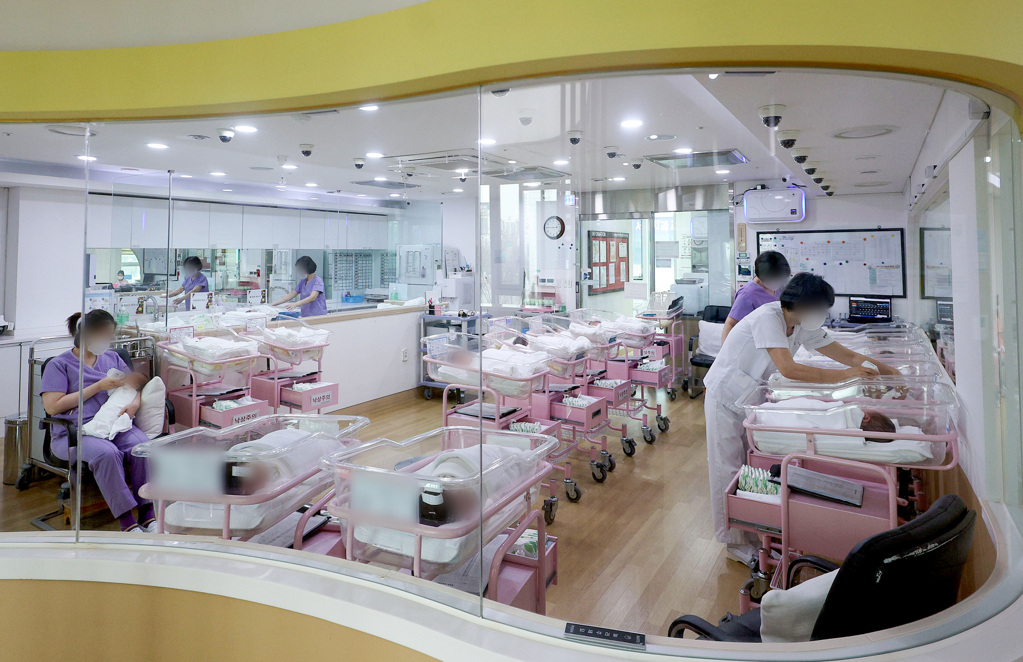 Postnatal caregivers take care of newborns at a center in Seoul. [YONHAP]