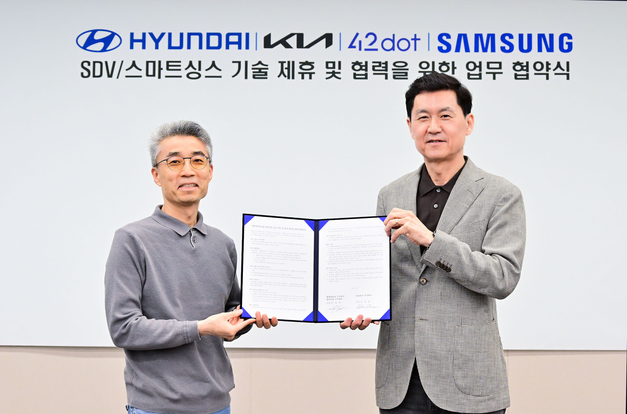 Chang Song, Hyundai Motor Group president and head of Advanced Vehicle Platform Division, left, and Cheun Kyung-hoon, Samsung Electronics president and chief technology officer of Device eXperience Division, pose for the photo after the signing ceremony to advance SmartThings platform and infotainment system at Samsung Electronics’ Seoul R&D Campus in southern Seoul on Wednesday. [SAMSUNG ELECTRONICS]