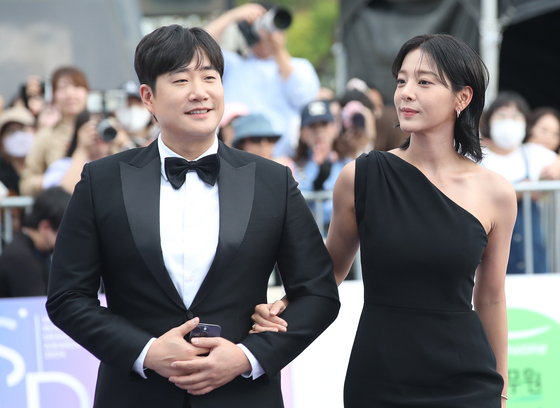 The hosts of the Seoul International Drama Awards walk down the awards' purple carpet in Yeouido, western Seoul, on Wednesday. From left, announcer Bae Seong-jae and actor Seor In-a [NEWS1]