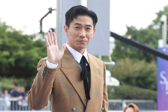 Singaporean actor Desmond Tan waves while walking down the Seoul International Drama Awards' purple carpet in Yeouido, western Seoul, on Wednesday. [YONHAP]