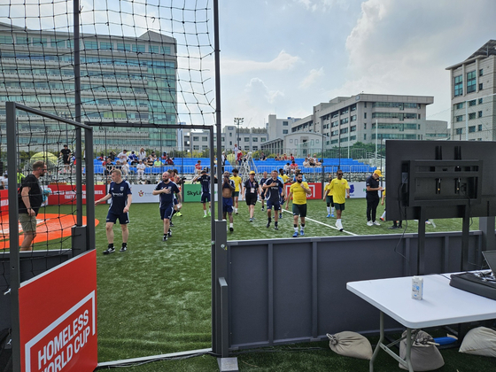 Team Australia, in yellow, and Team Scotland come off the pitch after a head-to-head match at the 2024 Homeless World Cup at Hanyang Unversity in eastern Seoul on Thursday. [PAIK JI-HWAN]