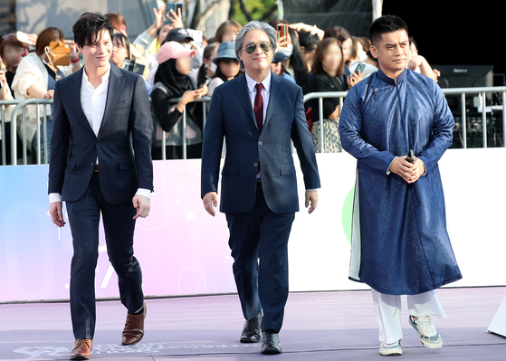 Actor Hoa Xuande, director Park Chan-wook and actor Fred Nguyen Khan walk down the Seoul International Drama Awards' purple carpet in Yeouido, western Seoul, on Wednesday. [NEWS1]