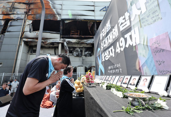 Families pray as they mourn for the workers killed in a fire at lithium battery maker Aricell's factory in Hwaseong in June. Among 23 killed in the fire, 18 were immigrant workers. [NEWS1]