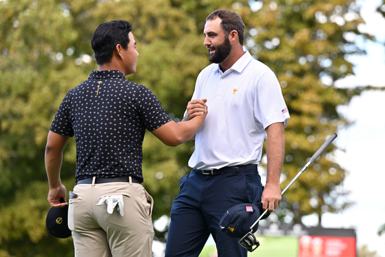 Tom Kim of the International Team and Scottie Scheffler of the U.S. Team shake hands after Scheffler and Russell Henley defeated Kim and Im Sung-jae 3 & 2 during Thursday's Four-ball matches on day one of the 2024 Presidents Cup at The Royal Montreal Golf Club in Montreal on Thursday.  [GETTY IMAGES]