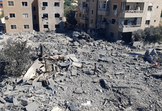 A man walks on the rubble of destroyed buildings at the site of Israeli strikes in Saksakiyeh, southern Lebanon Sept. 26, 2024. [REUTERS/YONHAP]