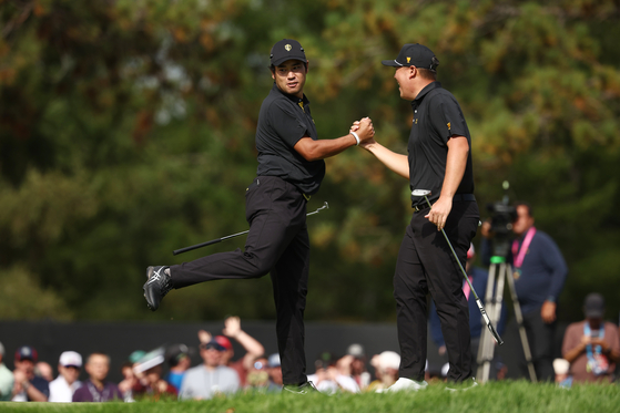 Hideki Matsuyama and the International Team celebrates with Im Sung-jae after a putt on the eighth green on day two of the 2024 Presidents Cup at The Royal Montreal Golf Club in Montreal on Friday.  [GETTY IMAGES]