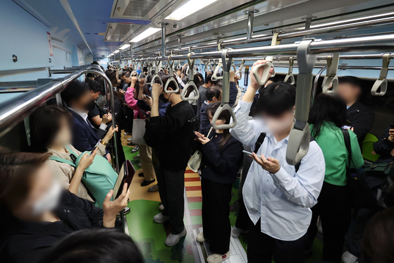 People look into their phones on a Seoul subway on May 16. [YONHAP]