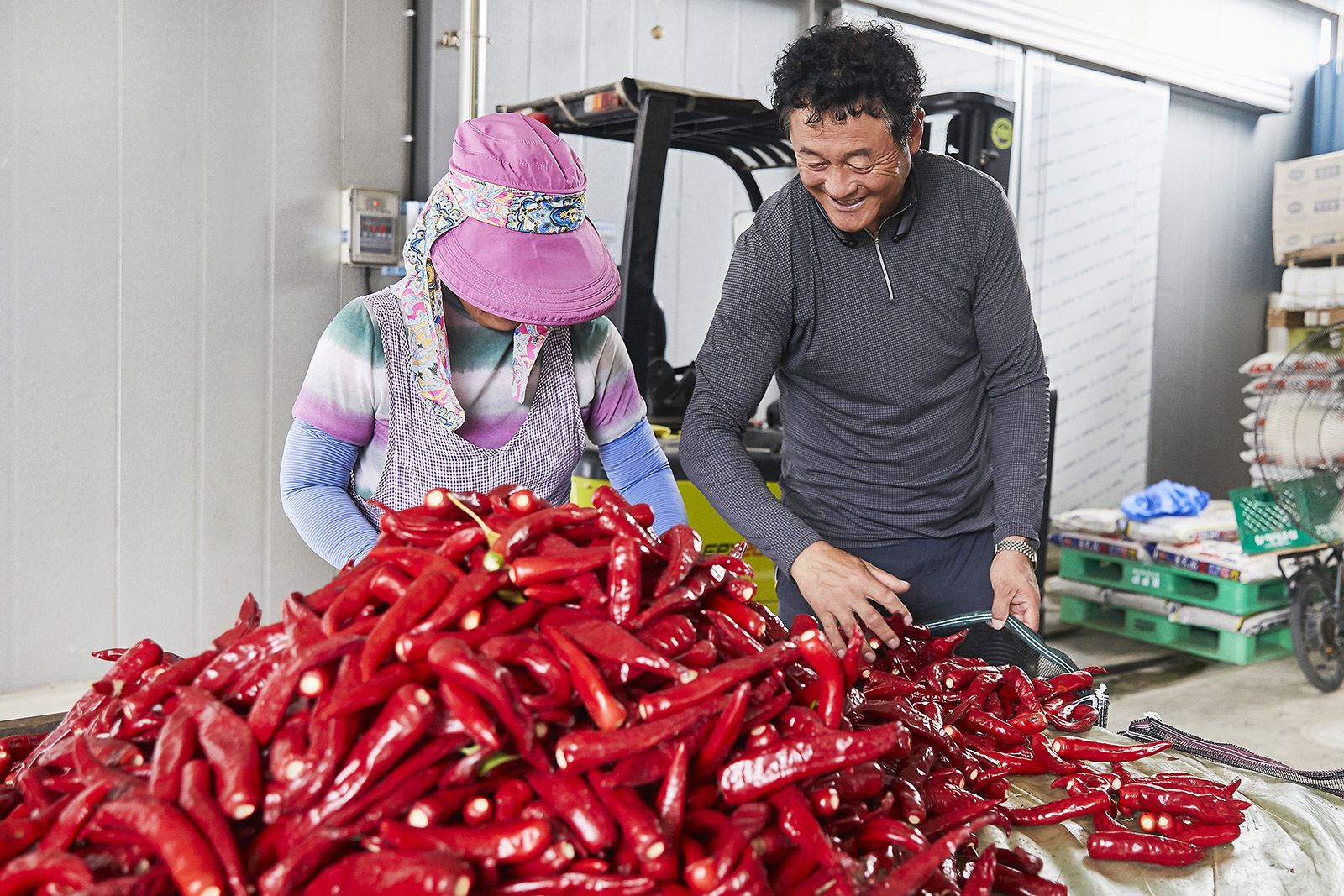 Farmer Lim Cheon-seob, right, has supplied red chili peppers to chicken franchise Kyochon through a contract agreement since 2022, according to Kyochon BHN Bio. [KYOCHON F&B]