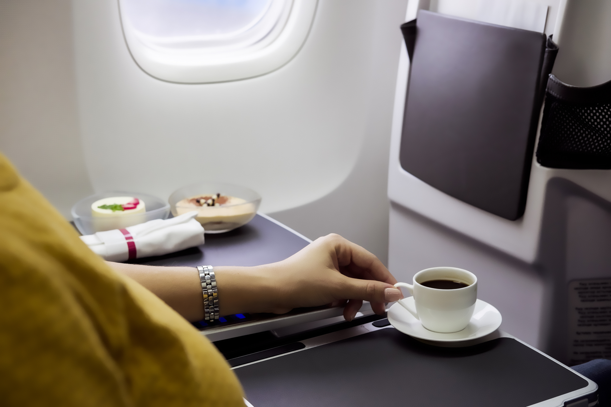 Cup of espresso on table in airplane interior [GETTY IMAGES]