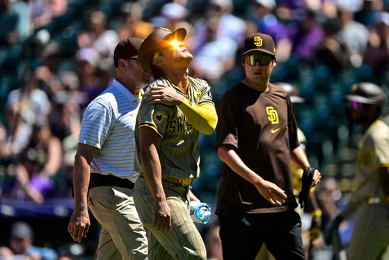 Kim Ha-seong of the San Diego Padres comes out of the game with an apparent upper body injury after sliding to avoid a pickoff attempt at first base in the third inning against the Colorado Rockies at Coors Field in Denver, Colorado on Aug. 18.  [AFP/YONHAP]