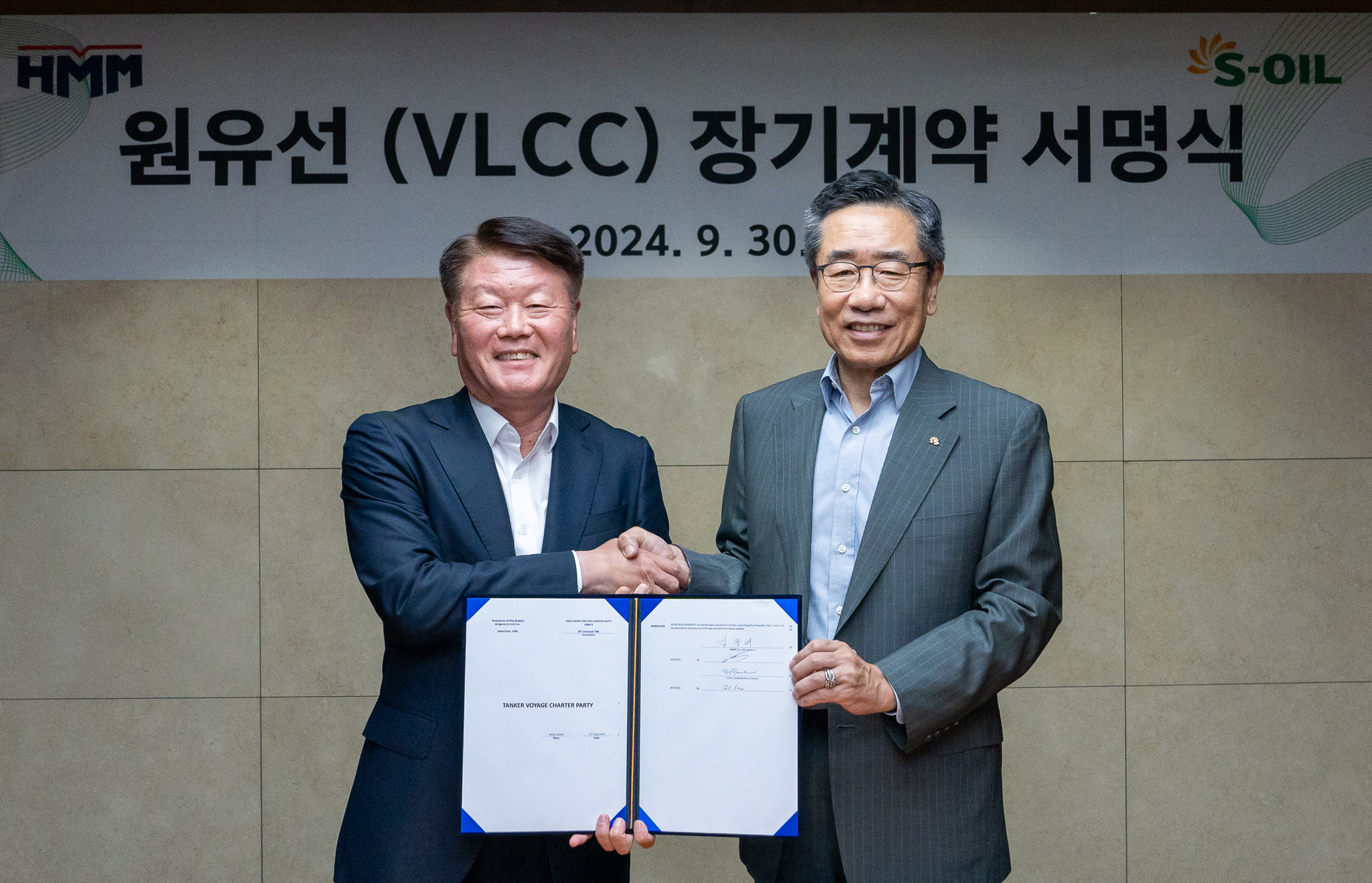 HMM CEO Kim Kyung-bae, left, and S-Oil President Park Bong-soo take a photo after signing a crude oil shipping contract on Monday at the oil refiner's headquarters in Mapo District, western Seoul. [HMM] 