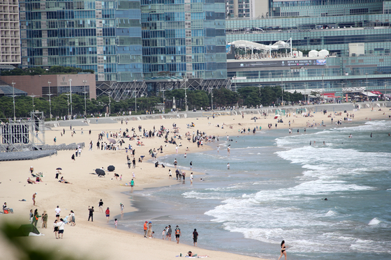 Beachgoers escape the early autumn heat at Haeundae Beach in Busan on Tuesday before the possible arrival of Typhoon Krathon later in the week. The city's daily high was 28.7 degrees Celsius (83.6 degrees Fahrenheit). [NEWS1]