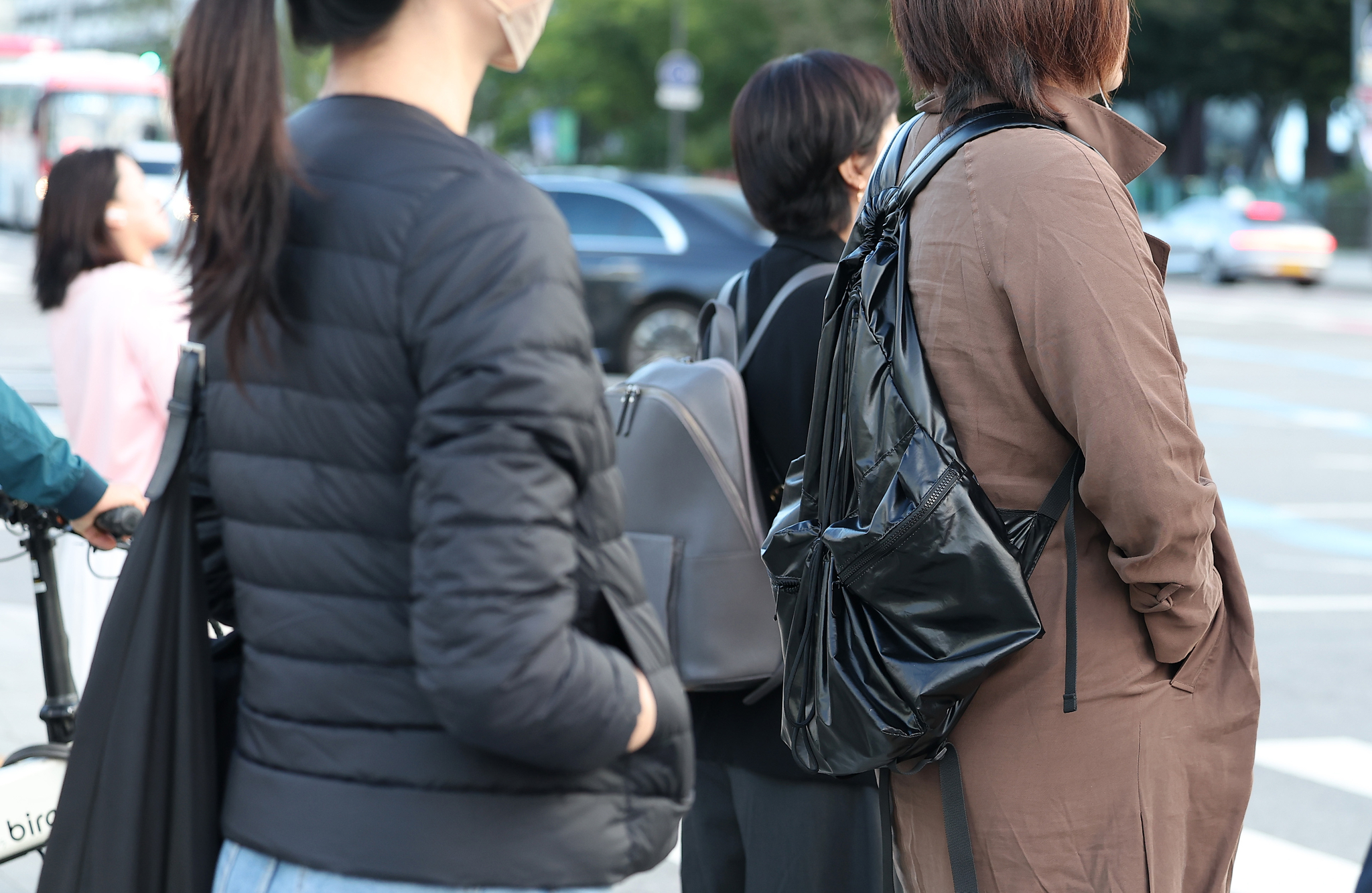 People wearing jackets and outerwear stand on streets in Jongno District, central Seoul, on Wednesday morning. [NEWS1]