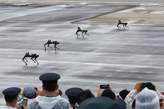 Spectators photograph quadruped robots crawling along the tarmac at a ceremony marking South Korea’s 76th Armed Forces Day at Seoul Air Base in Seongnam, Gyeonggi, Tuesday. [YONHAP]