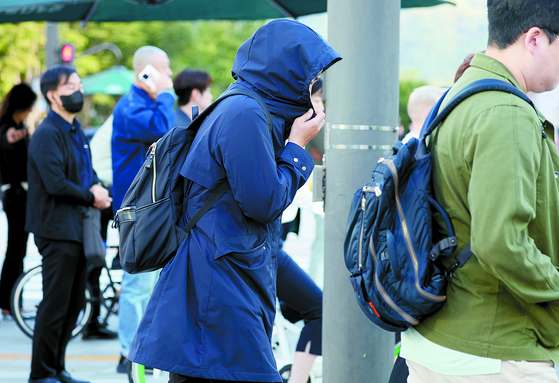 Pedestrians try to keep themselves warm with outerwear and jackets as autumn temperatures dropped on Wednesday morning in Jongno District, central Seoul. The capital's morning temperatures dipped to 12.1 degrees Celsius (53.78 degrees Fahrenheit) at 6 a.m. on the same day, according to the Korea Meteorological Administration. [YONHAP] 