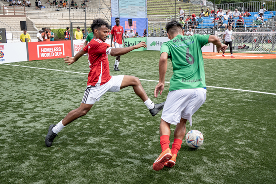 England's Mikiale Tsegay, left, vies for the ball during a 2024 Homeless World Cup match against Mexico at Hanyang University in eastern Seoul on Thursday. [HOMELESS WORLD CUP]