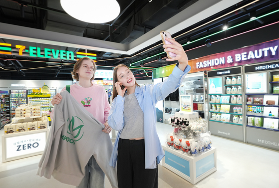 Models take a selfie at the new 7-Eleven store in DunDun shopping mall in Jung District, central Seoul [7-ELEVEN] 