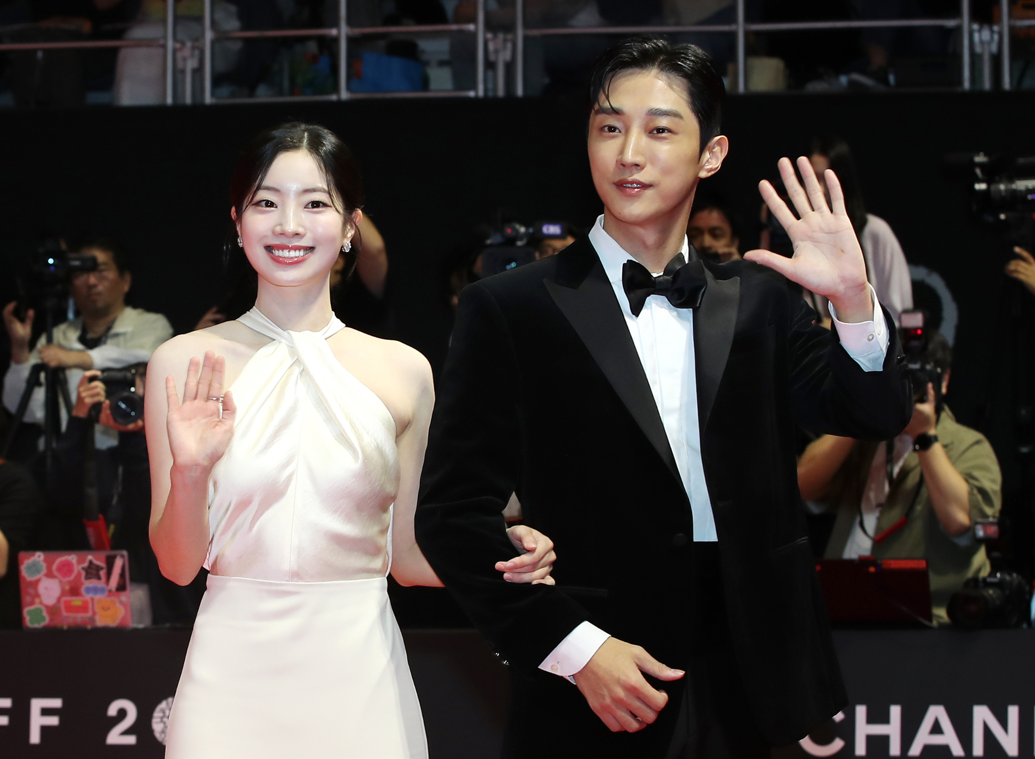 Girl group Twice's Dahyun, left, and singer Jinyoung walk down the red carpet ahead of the festival's opening ceremony held at the Busan Cinema Center in Haeundae District on Wednesday.[NEWS1]