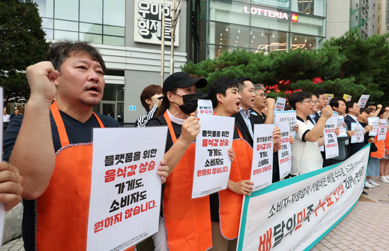 Restaurant owners listed on delivery app Baedal Minjok protest the platform's commission hike in front of operator Woowa Brothers' offices in Songpa District, southern Seoul, on Aug. 7, 2024. [NEWS1]