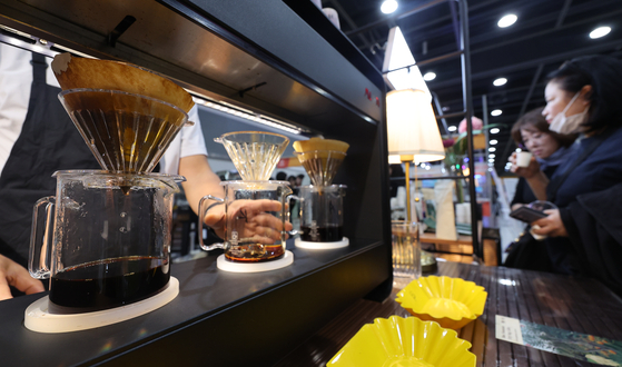 Visitors taste coffee during the Seoul Coffee & Tea Fair at the aT Center in Seocho District, southern Seoul, on Thursday morning. [YONHAP]