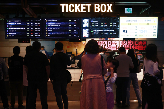 Theatergoers buy tickets at a cinema in Seoul in June. [YONHAP]