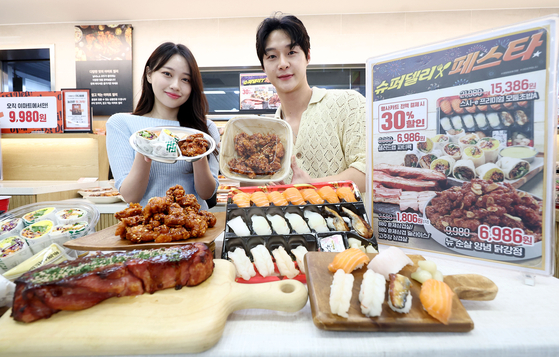 Models present discount products at Emart's Yongsan branch in central Seoul on Thursday. [YONHAP]