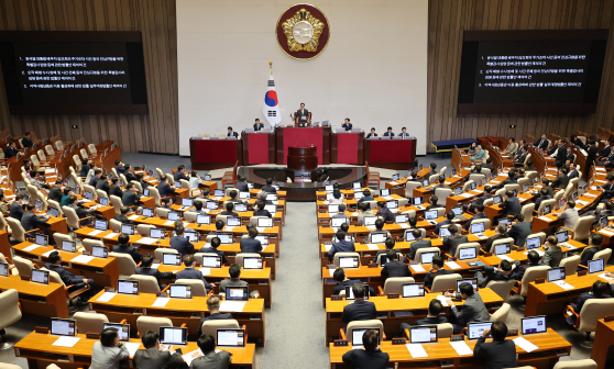 Lawmakers vote at the National Assembly in the Yeouido, western Seoul, on Friday. [YONHAP]