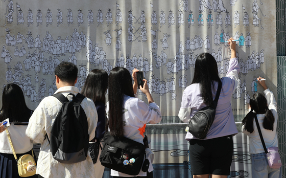 Visitors color a painting, inspired by byeongpung (folding screen) featuring Hwaseong at this year's Suwon Hwaseong Cultural Festival. [NEWS1]