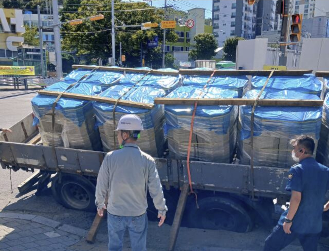 A 25-ton truck lies in the sinkhole that opened up in Incheon on Friday. [INCHEON FIRE SERVICES] 